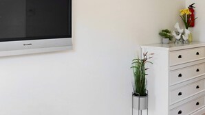 A white wall with a flat-screen television mounted above a white dresser with drawers. - 4 Person Holiday Home in Falkenberg (Falkenberg)