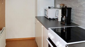 A compact kitchen with a microwave, toaster, and coffee maker on the countertop. - 4 Person Holiday Home in Falkenberg (Falkenberg)