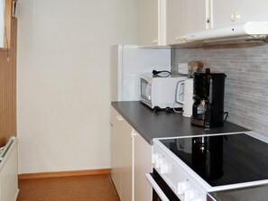 A compact kitchen with a microwave, toaster, and coffee maker on the countertop. - 4 Person Holiday Home in Falkenberg (Falkenberg)