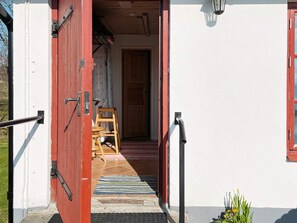 A doorway with a wooden chair and a rug, leading to an interior space. - 5 Person Holiday Home in Vollsjo (Vollsjö)