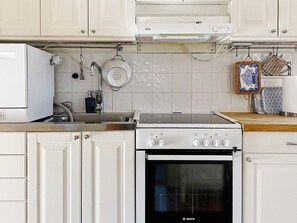 A kitchen with white cabinets, a Bosch stove, and a sink.