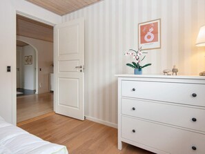 A room with a white dresser, a door, and a hallway leading to another room. - 5 Star Holiday Home in Vinderup (Vinderup)