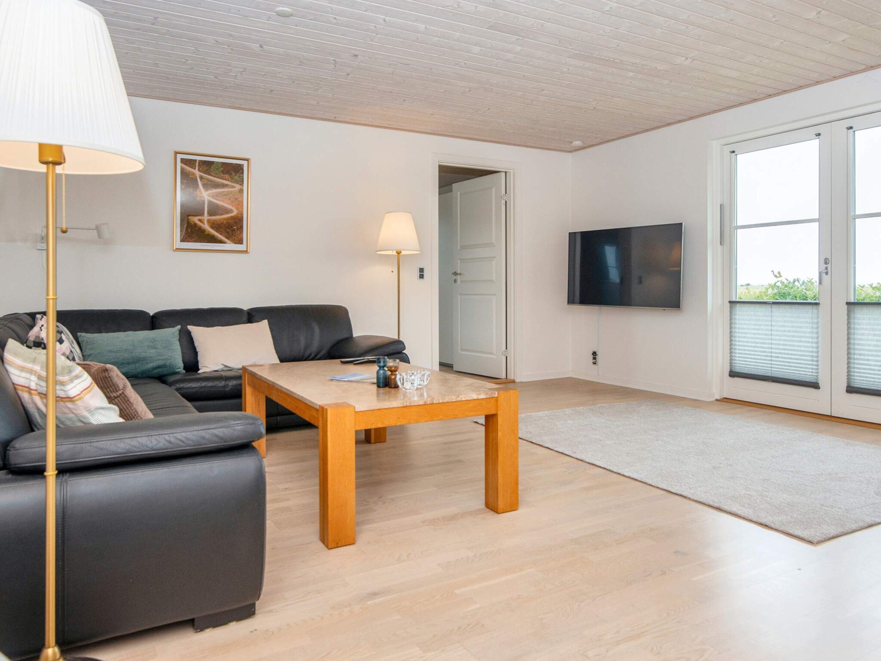 Uma sala de estar moderna com sofá, mesa de centro e abajur.