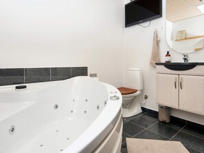 A modern bathroom with a freestanding bathtub, a toilet, a sink, and a mirror. - 5 Star Holiday Home in Vinderup (Vinderup)