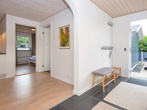 A hallway with a bench, a door leading to a kitchen, and a view of the outside. - 5 Star Holiday Home in Vinderup (Vinderup)