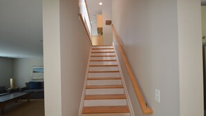 Un escalier avec des marches en bois et une rampe, menant à l’étage supérieur.