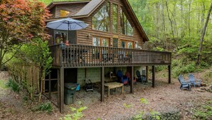 Eine Hütte mit einer Terrasse, großen Fenstern und einer Satellitenschüssel.
