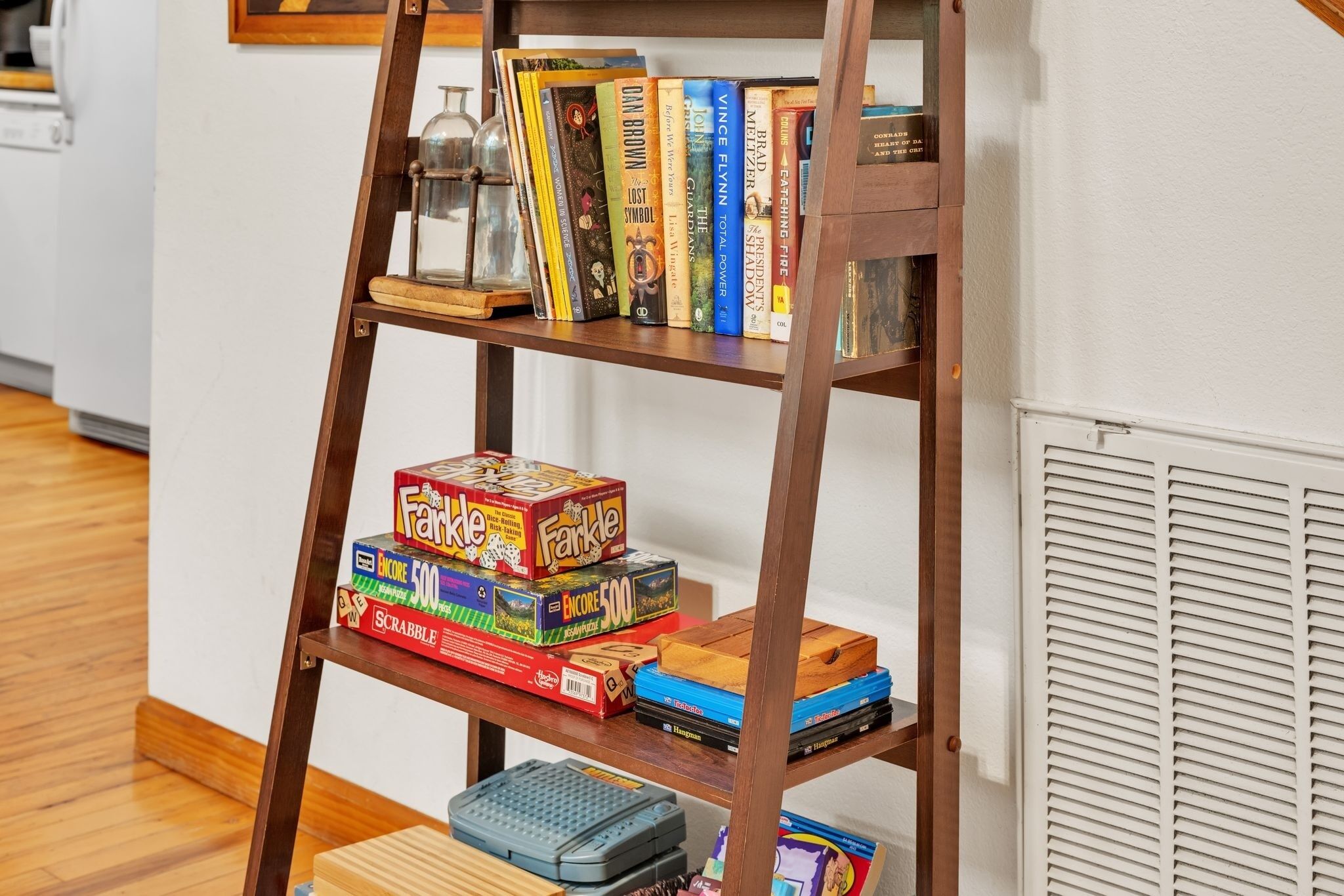 A wooden bookshelf with various board games and books.