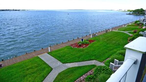 A waterfront promenade with a paved walkway, grassy areas, and a view of the water. - Harbour Island 306l 2 Bedroom Condo by RedAwning (Ocean City)