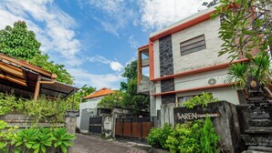A guest house with a sign, a paved entrance, and surrounding greenery. - Hotel O Canggu Near Echo Beach Formerly Saren Guesthouse (Kerobokan)
