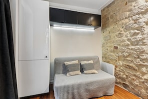 Ein kleiner Raum mit Einbauschrank, einer gepolsterten Sitzecke und einer Steinwand.