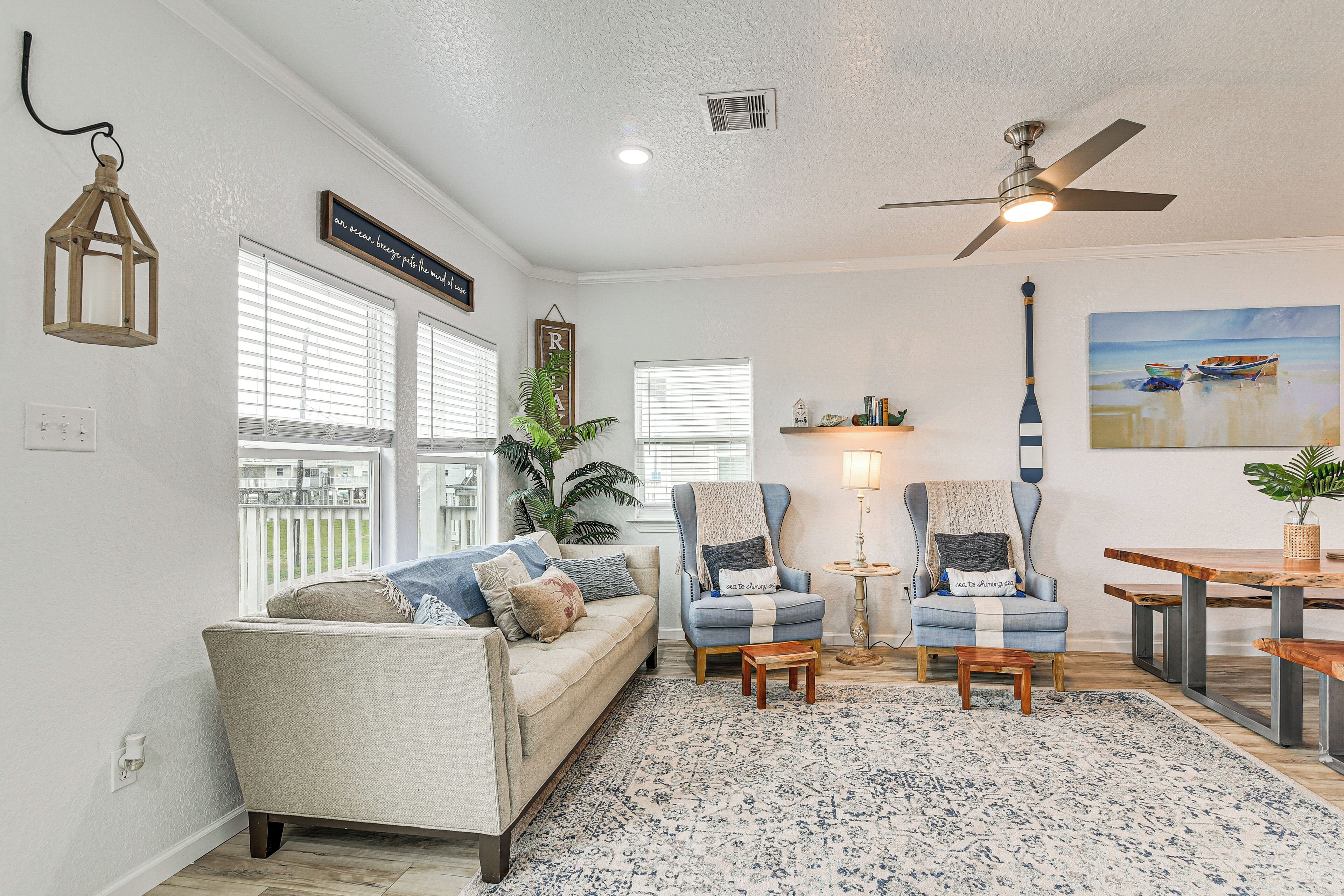 A living room with a sofa, two armchairs, a coffee table, and a dining table.