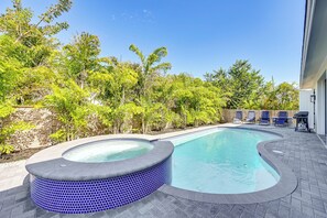 A swimming pool with a hot tub, surrounded by a brick patio and lush greenery. - Marco Island Home w/ Pool & Hot Tub Near Beaches! (Marco Island)