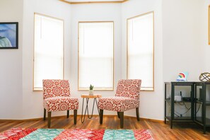 A room with two patterned armchairs, a small table, and a colorful rug. - Charming Home - 2 Mi to Niagara Falls State Park! (Niagara Falls)