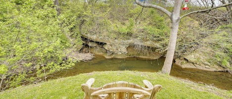 A wooden bench in a park with a river and trees.
