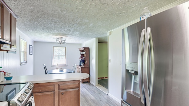A kitchen with wooden cabinets, a stainless steel refrigerator, and a built-in oven. - Home w/ Bunkroom: 2 Mi to Hatfield & Mccoy Trail (Bluefield)