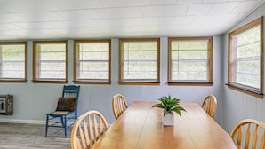 A dining area with a wooden table, six chairs, and a potted plant. - Home w/ Bunkroom: 2 Mi to Hatfield & Mccoy Trail (Bluefield)