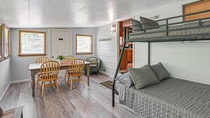 A compact room with a bunk bed, a dining table with chairs, and a small kitchen area. - Home w/ Bunkroom: 2 Mi to Hatfield & Mccoy Trail (Bluefield)
