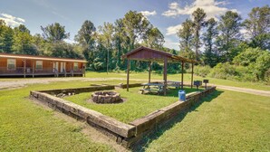 A campsite with a wooden fire pit, picnic tables, and a covered picnic shelter. - ATV Trails & Adventure: Briceville Mountain Studio (Briceville)