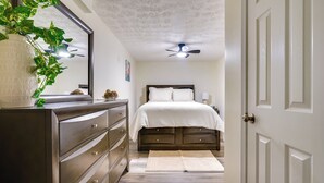 A bedroom with a bed, dresser, and ceiling fan. - Pet-friendly Zanesville Haven w/ Game Room! (Zanesville)