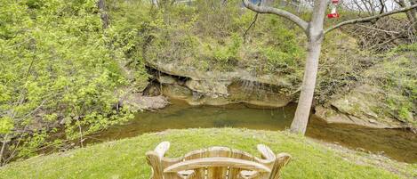 A wooden bench in a park with a river and trees.