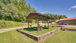A covered picnic area with benches and picnic tables, surrounded by a brick building and a blue truck parked nearby. - ATV Trail Access: Mountain-view Briceville Studio! (Briceville)