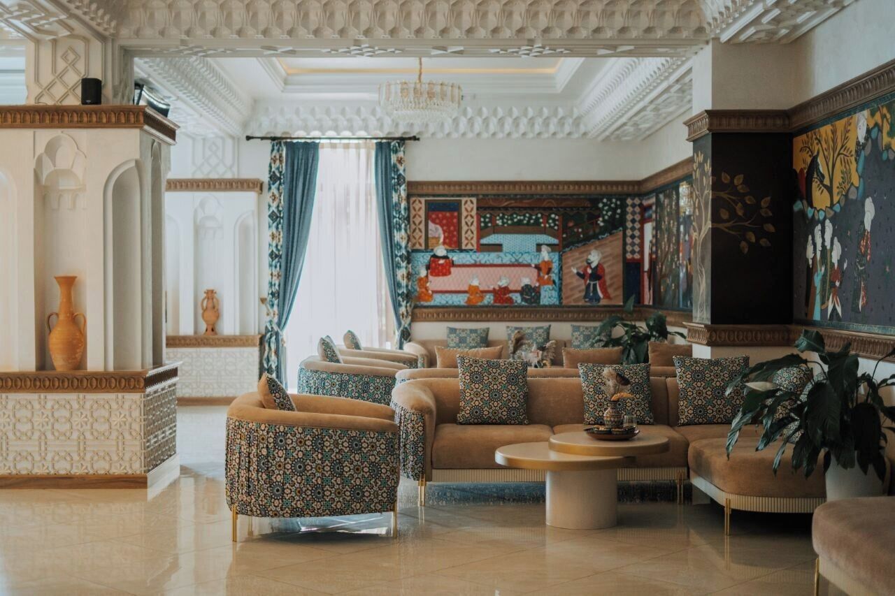 A luxurious lobby with ornate ceiling, patterned walls, and comfortable seating areas.