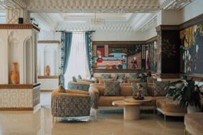 A luxurious lobby with ornate ceiling, patterned walls, and comfortable seating areas. - Kohinur Plaza (Samarkand)