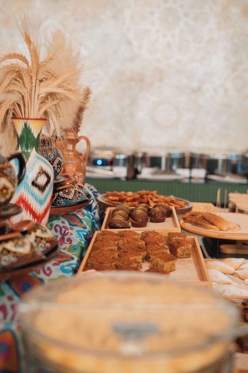 A buffet table with various food items and traditional pottery.