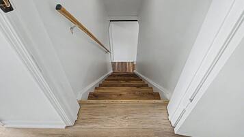 Un escalier avec des marches en bois et des murs blancs.