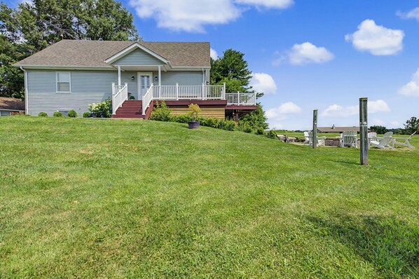 A two-story house with a front porch and a small deck.