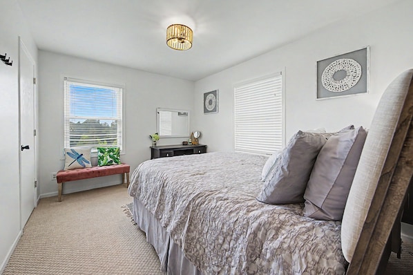 A bedroom with a bed, a bench, a dresser, and a window with blinds. - Home with LAKE VIEW! Foosball, Skee ball (Apple River)