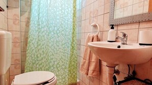 A bathroom with a toilet, sink, and shower curtain.