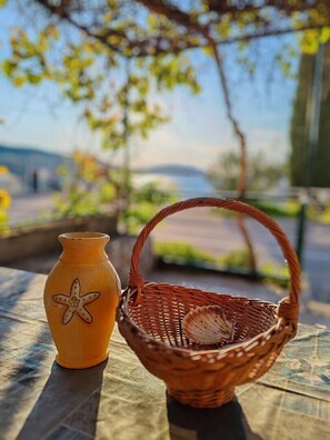 A wicker basket with a seashell and a ceramic vase with a star design on a table.