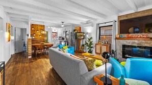 A spacious living area with a dining table, sofas, and a fireplace.