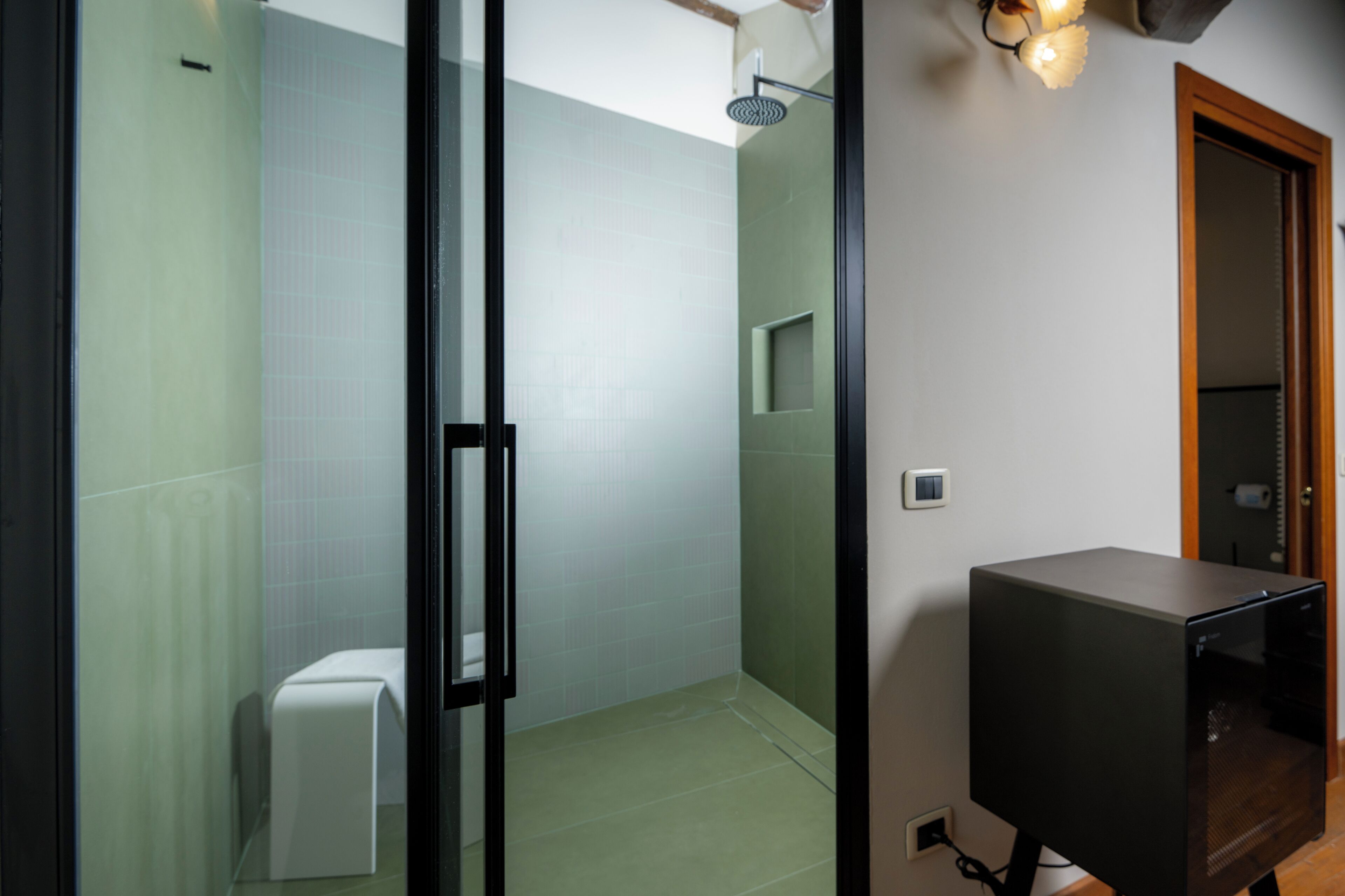 A modern bathroom with a glass shower enclosure, a toilet, and a built-in sink.