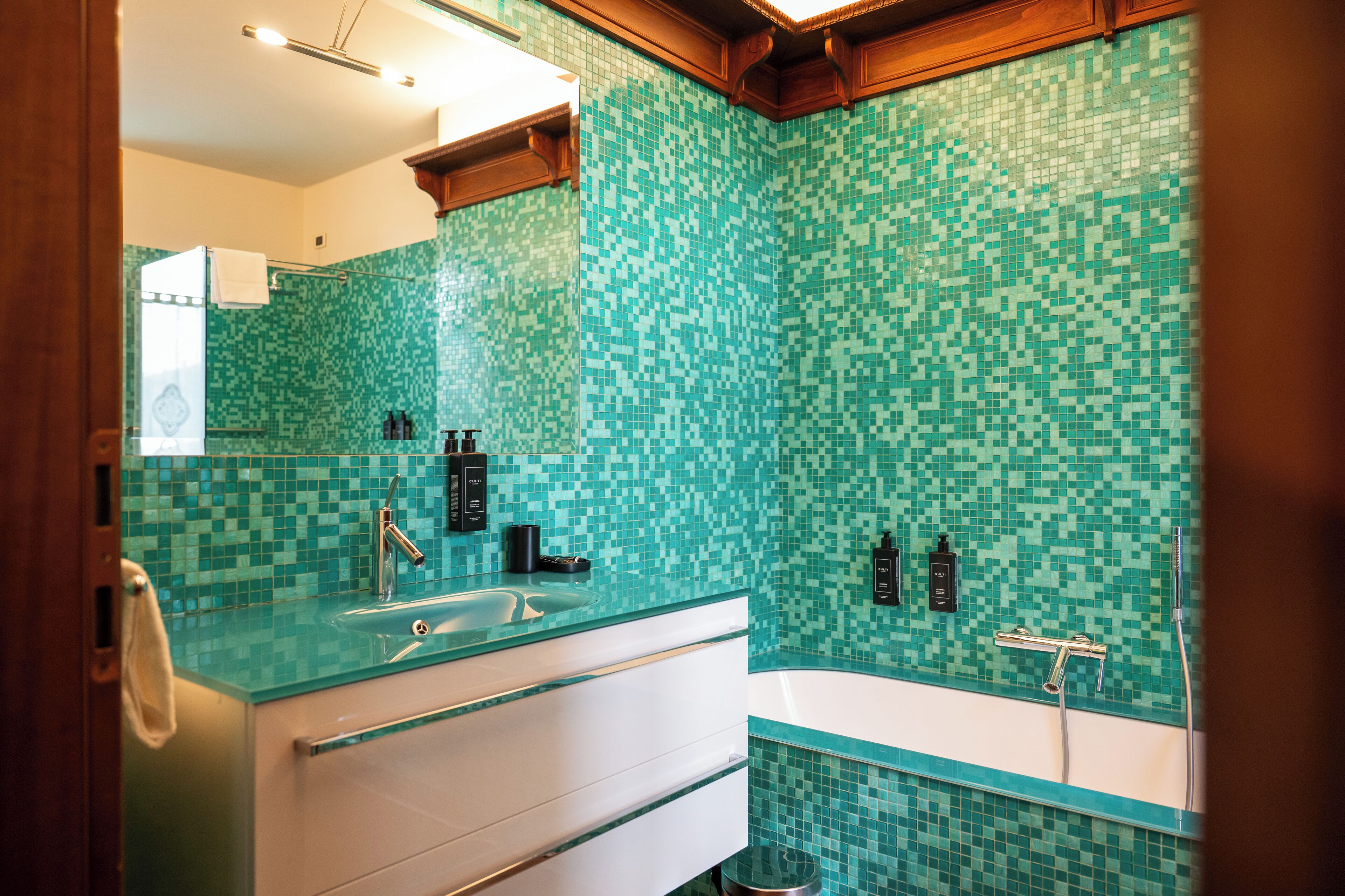 Une salle de bain avec un lavabo en verre, un meuble-lavabo blanc et une baignoire.