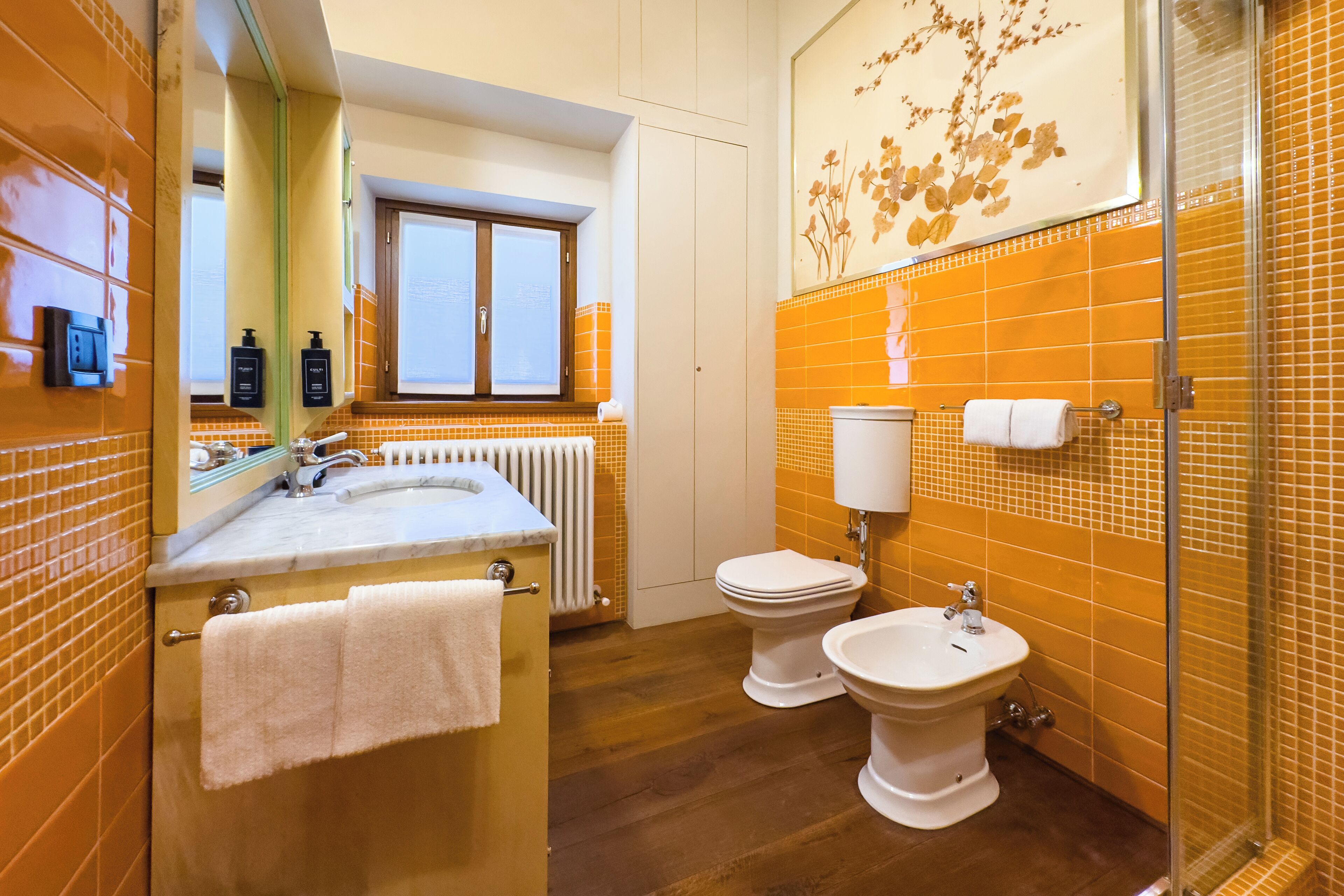 Et badeværelse med håndvask, to toiletter og et bidet.