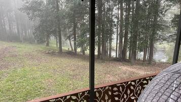 A view from a room with a large window overlooking a forested area.