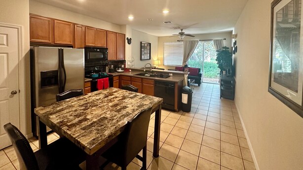 Una cocina moderna con armarios de madera, electrodomésticos de acero inoxidable y una zona de comedor con mesa de mármol.