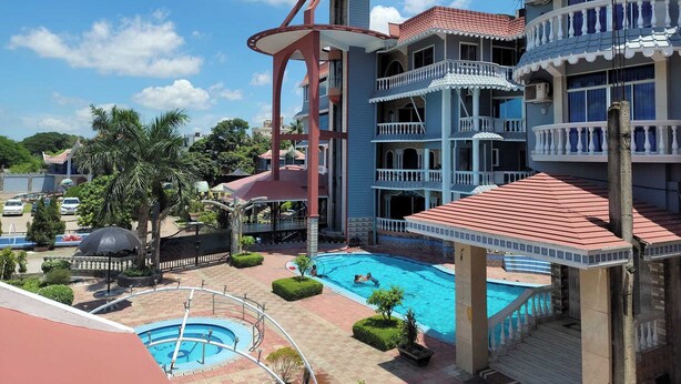 A resort with a swimming pool, a water slide, and a multi-story building with balconies. - The Silver Castle  (Mymensingh)