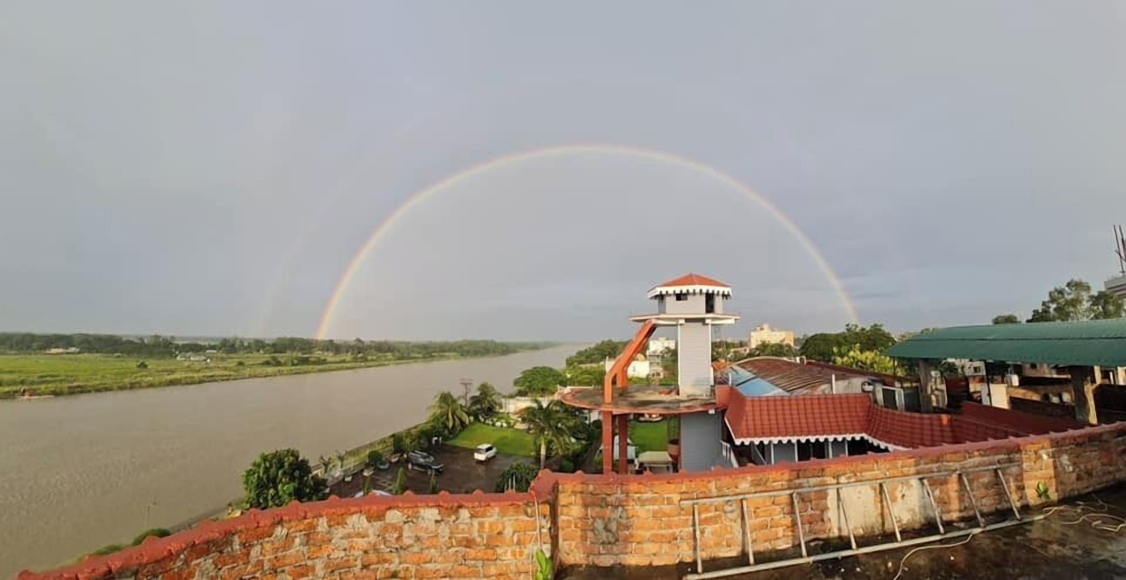 Vista al río con un muro de ladrillo y una pequeña estructura similar a una torre.
