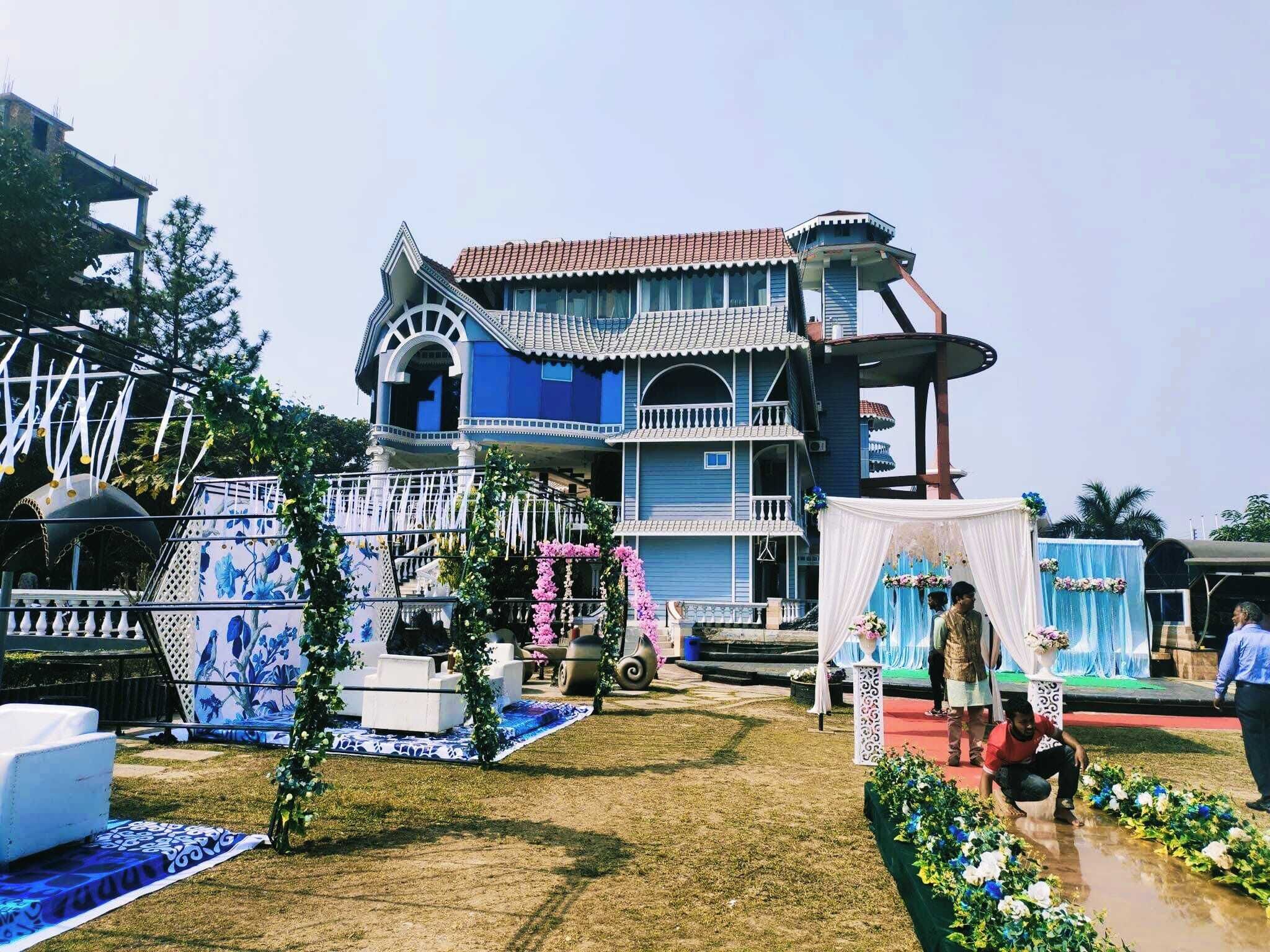 A two-story building with a blue facade and a red-tiled roof.