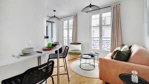 Ein moderner Wohnraum mit Essbereich, einer Couch und einem runden Couchtisch.