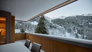 Una habitación con un ventanal que da a un paisaje nevado de montaña.