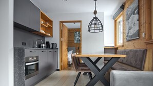 Una cocina moderna con armarios grises, una mesa de comedor de madera y un banco.