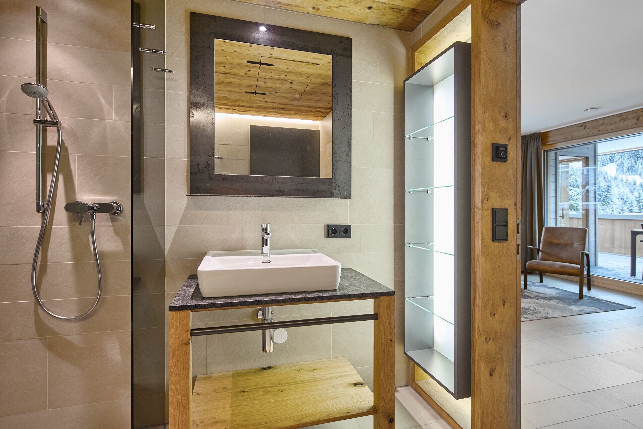 Une salle de bain moderne avec un meuble-lavabo en bois, un grand miroir et une cabine de douche en verre.