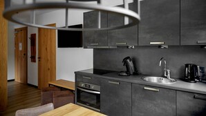 A modern kitchen with dark cabinets, a stainless steel sink, and a coffee maker. - 59114 Fels-Schwalbe 114 (Gargellen)