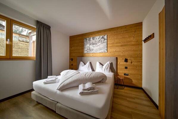 Relax in a spacious room with a large bed, framed artwork, and a large window.