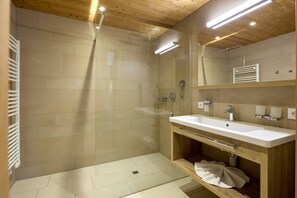 Enjoy a refreshing shower in the walk-in shower with a handheld showerhead and wall-mounted faucet.